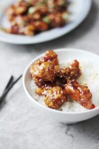 Bowl of rice with general tso's chicken.