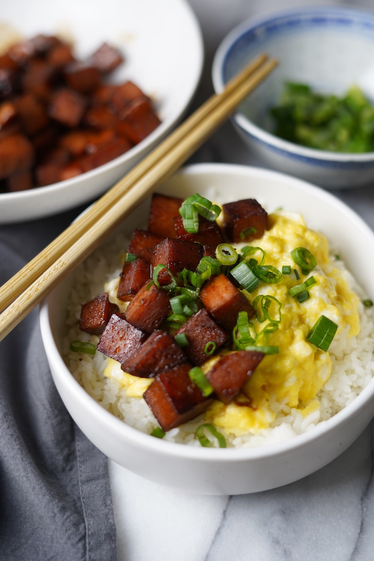 Bowl of rice topped with cubed spam and scrambled eggs.