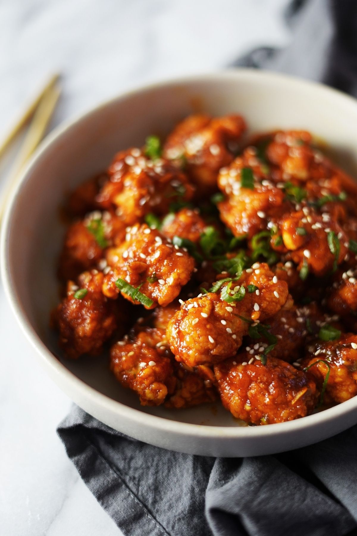A bowl of fried chicken with gochujang sauce.