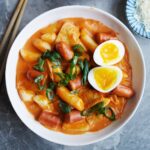 Bird's view of rose tteokbokki served in a bowl.