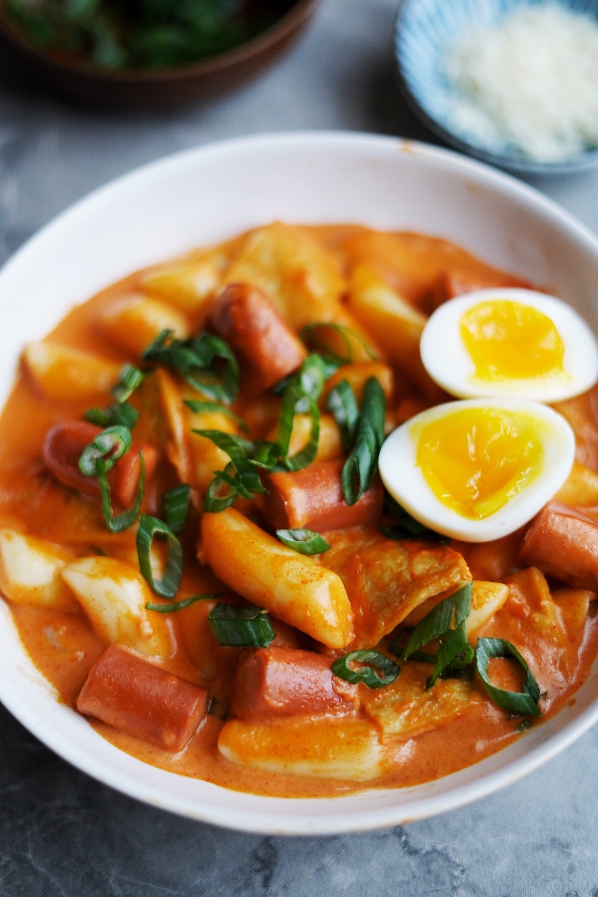 Close up front view of rose tteokbokki served in a bowl.